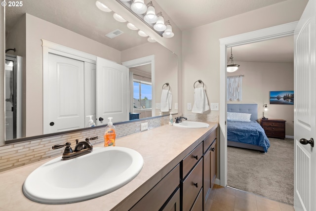 full bathroom with visible vents, a sink, backsplash, and connected bathroom