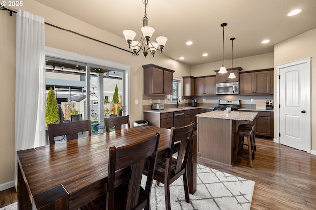dining area featuring recessed lighting, baseboards, an inviting chandelier, and light wood-style floors