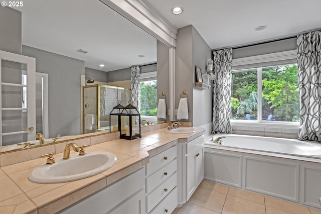 bathroom featuring a shower stall, tile patterned floors, a garden tub, and double vanity