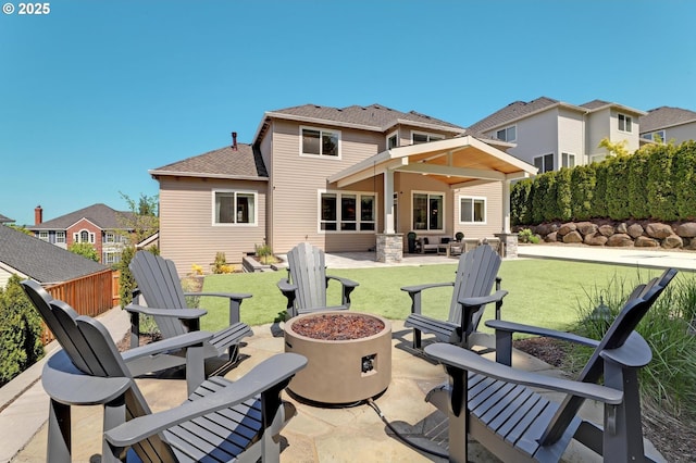 rear view of property with a patio area, a fire pit, a yard, roof with shingles, and a residential view