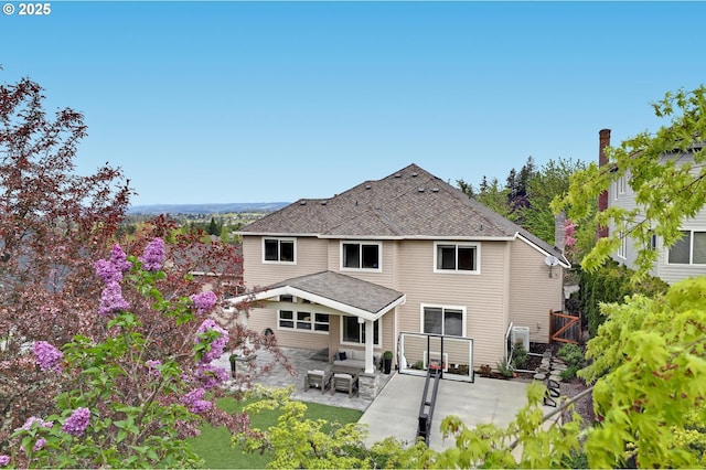back of property featuring a patio area and a shingled roof