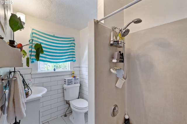 3905 SE 54th Ave, Portland, OR 97206 - full bath with tile patterned flooring, toilet, tile walls, and a textured ceiling