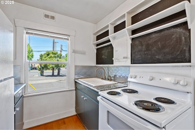 3905 SE 54th Ave, Portland, OR 97206 - kitchen with white range with electric cooktop, a sink, light wood finished floors, open shelves, and light countertops