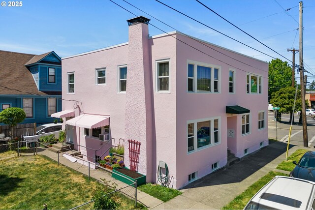 3905 SE 54th Ave, Portland, OR 97206 - view of side of home with stucco siding, fence, and a chimney