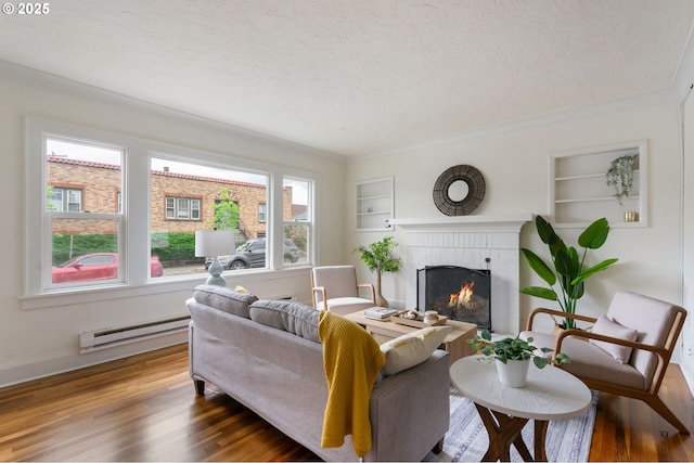 3905 SE 54th Ave, Portland, OR 97206 - living room featuring a baseboard heating unit, wood finished floors, a brick fireplace, a textured ceiling, and built in shelves