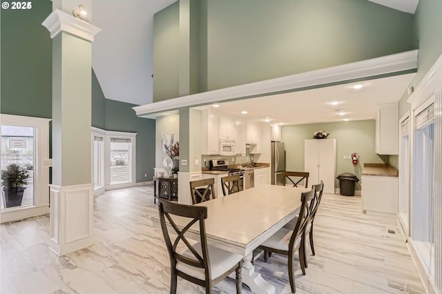 dining space with a high ceiling, ornate columns, and sink