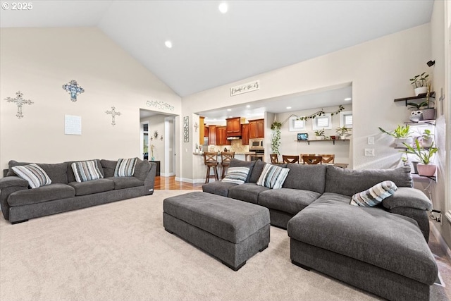 living room with light carpet and high vaulted ceiling