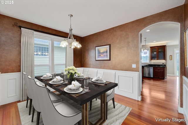 dining room with light wood-type flooring and a chandelier