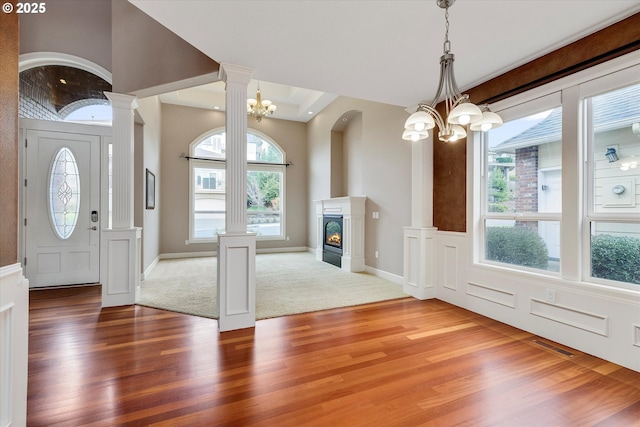 entryway with a wealth of natural light, hardwood / wood-style flooring, and a notable chandelier