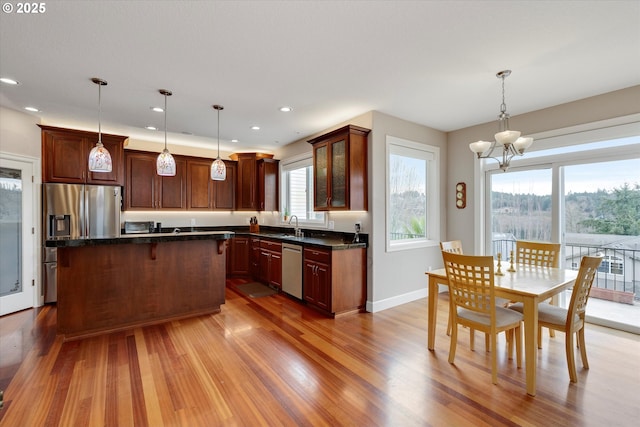 kitchen featuring pendant lighting, a center island, appliances with stainless steel finishes, and a chandelier