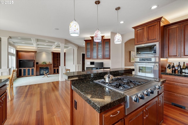 kitchen with pendant lighting, a center island, coffered ceiling, appliances with stainless steel finishes, and beam ceiling