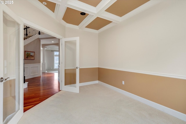 spare room with carpet flooring, beam ceiling, crown molding, and coffered ceiling