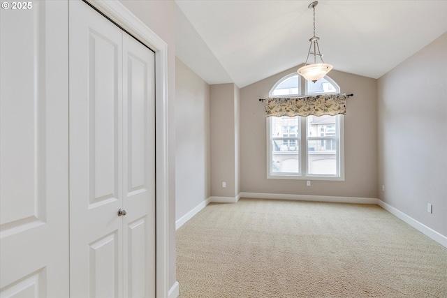 spare room with light colored carpet and lofted ceiling