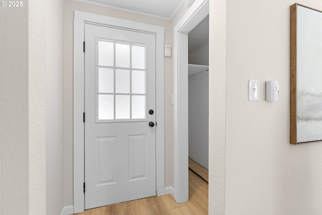 entryway featuring a wealth of natural light, light wood-type flooring, and a textured wall