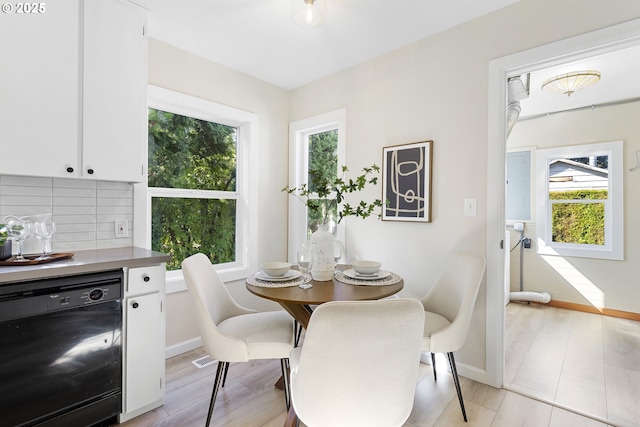 dining space featuring light wood-type flooring and baseboards