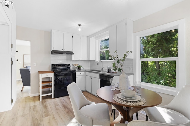 kitchen with backsplash, under cabinet range hood, black appliances, white cabinetry, and a sink