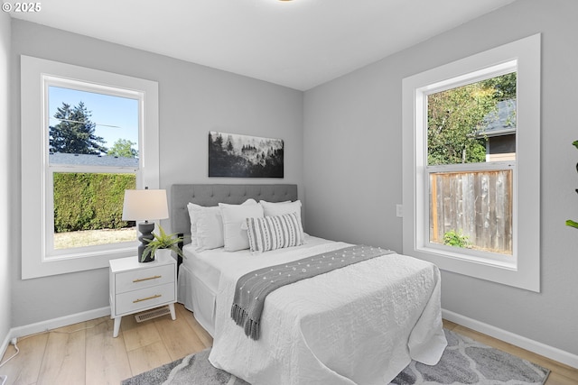 bedroom with light wood finished floors and baseboards