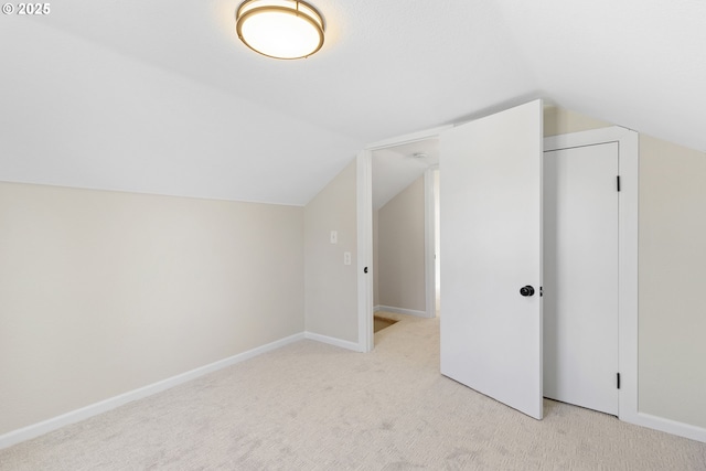 bonus room featuring baseboards, vaulted ceiling, and light colored carpet