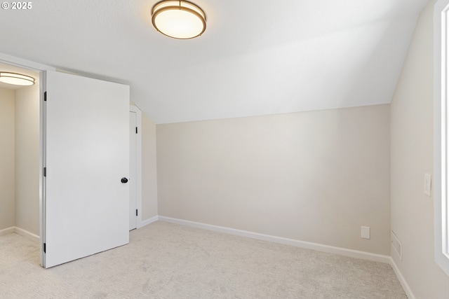 additional living space with light carpet, baseboards, and lofted ceiling