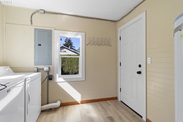 laundry room featuring light wood-type flooring, laundry area, washing machine and dryer, and electric panel