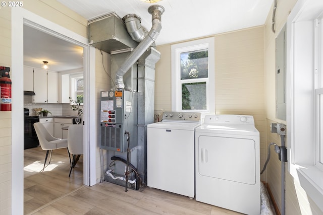 washroom featuring a sink, laundry area, separate washer and dryer, and light wood finished floors