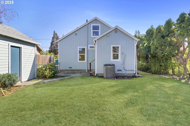 rear view of property with a yard, central AC unit, and fence