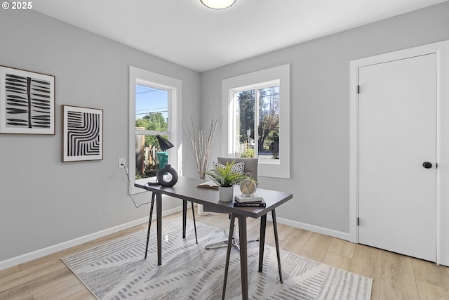 office featuring light wood-style flooring, baseboards, and a wealth of natural light