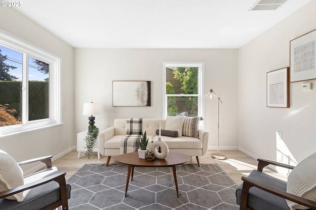 living room featuring wood finished floors, visible vents, and baseboards