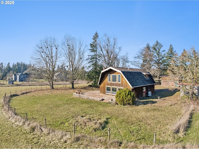 view of home's exterior featuring an outbuilding, a yard, and a rural view