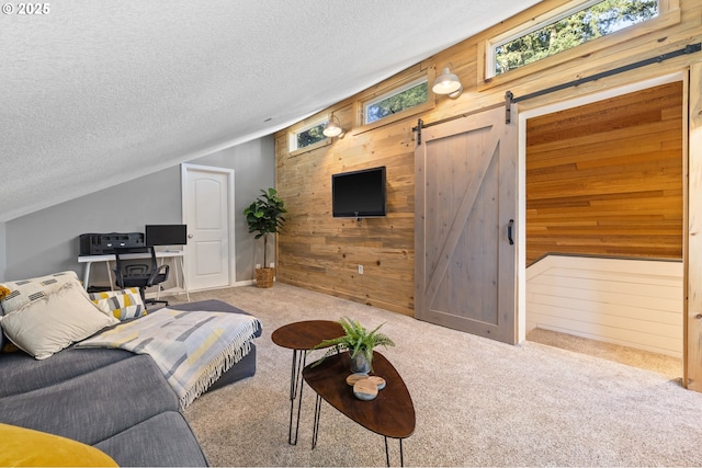 27650 SW Canyon Creek Rd, Wilsonville, OR 97070 - carpeted living room with wood walls, a textured ceiling, plenty of natural light, vaulted ceiling, and a barn door