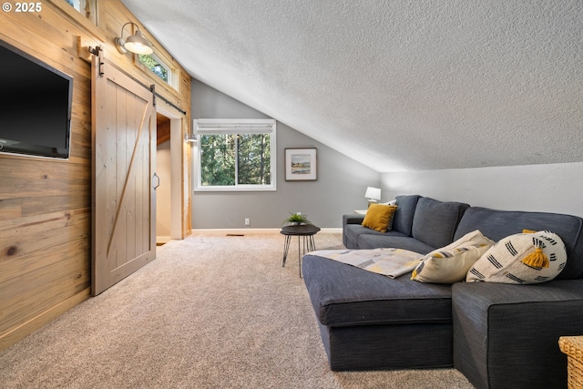 27650 SW Canyon Creek Rd, Wilsonville, OR 97070 - living room featuring a barn door, vaulted ceiling, a textured ceiling, carpet, and baseboards