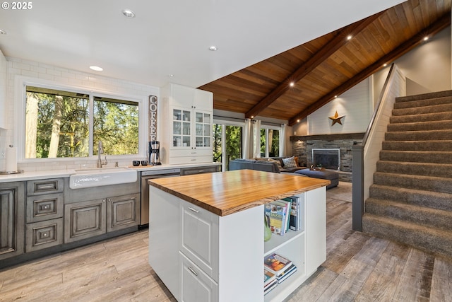 27650 SW Canyon Creek Rd, Wilsonville, OR 97070 - kitchen with a sink, dishwasher, wood ceiling, a stone fireplace, and butcher block counters