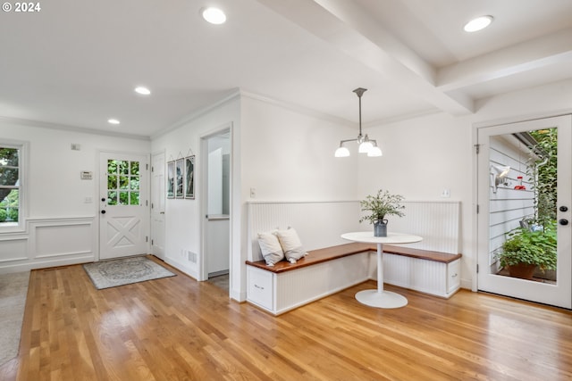 foyer entrance with breakfast area, crown molding, a chandelier, light hardwood / wood-style flooring, and beam ceiling