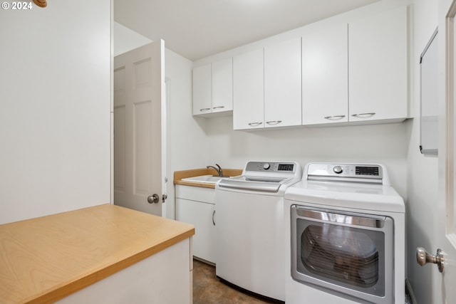 washroom with sink, washing machine and clothes dryer, and cabinets