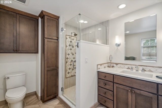 bathroom with an enclosed shower, vanity, toilet, and tasteful backsplash