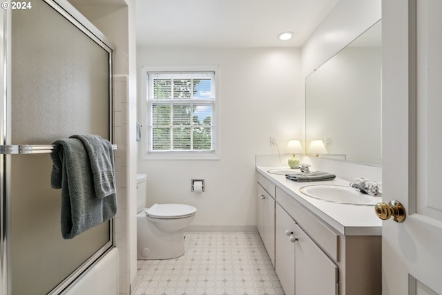 full bathroom featuring toilet, vanity, and shower / bath combination with glass door