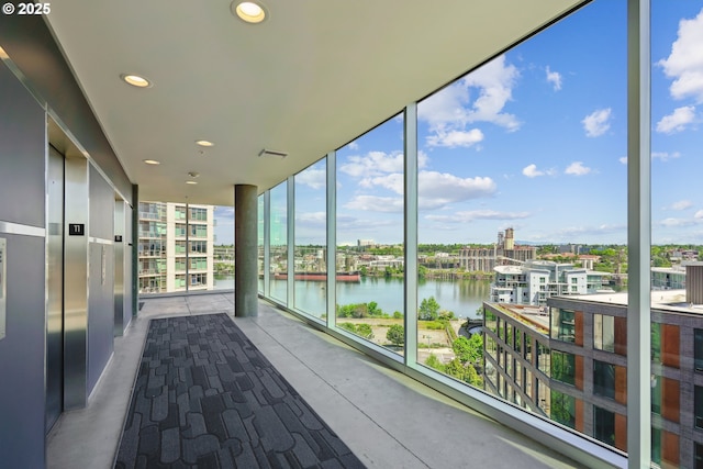 unfurnished sunroom featuring a water view
