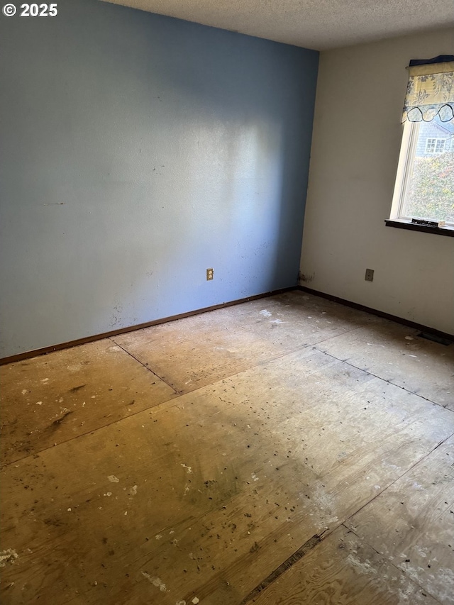 unfurnished room featuring a textured ceiling