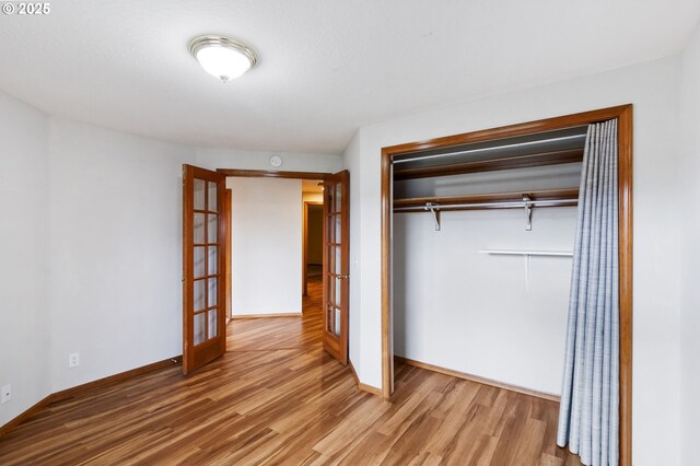 2744 Dayna Ln, Eugene, OR 97408 - unfurnished bedroom with french doors, wood finished floors, a closet, and baseboards