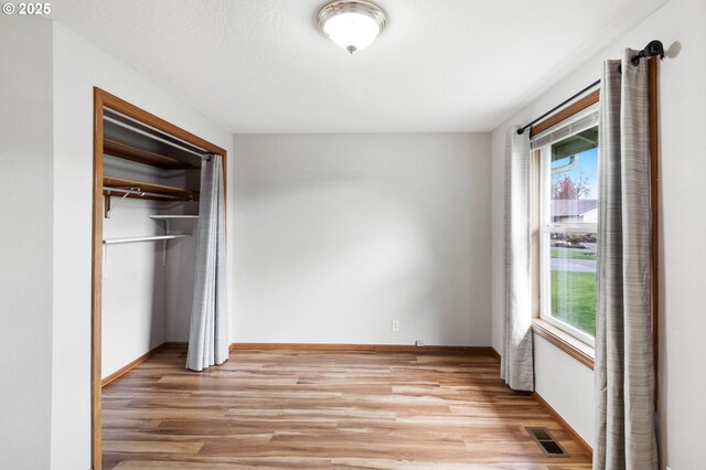 2744 Dayna Ln, Eugene, OR 97408 - unfurnished bedroom with light wood-type flooring, multiple windows, a closet, and baseboards
