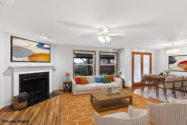 2744 Dayna Ln, Eugene, OR 97408 - living area with a ceiling fan, a chandelier, a fireplace, baseboards, and wood finished floors
