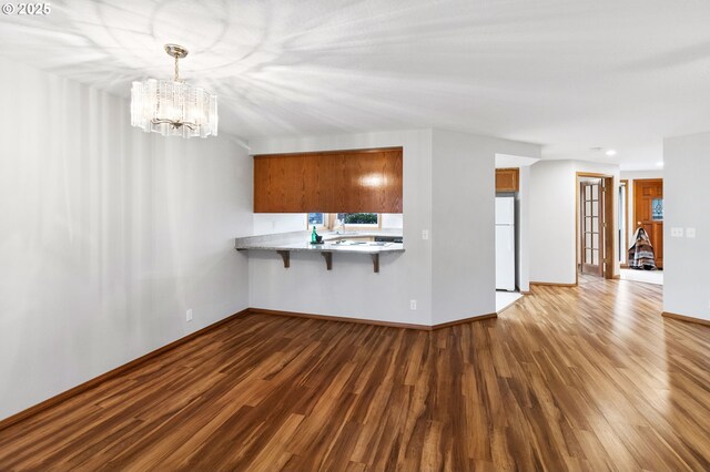 2744 Dayna Ln, Eugene, OR 97408 - unfurnished living room featuring dark wood-type flooring, a chandelier, baseboards, and recessed lighting