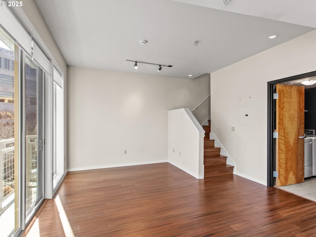 spare room with light hardwood / wood-style floors, rail lighting, and a healthy amount of sunlight