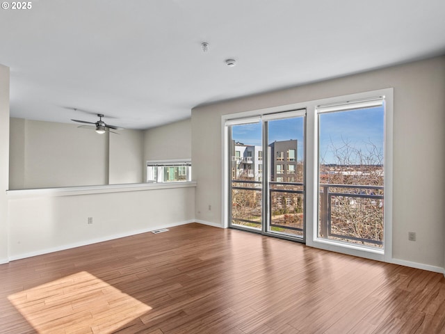 unfurnished room with ceiling fan and hardwood / wood-style floors