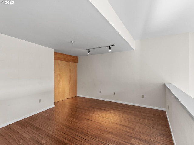 spare room featuring hardwood / wood-style flooring and rail lighting