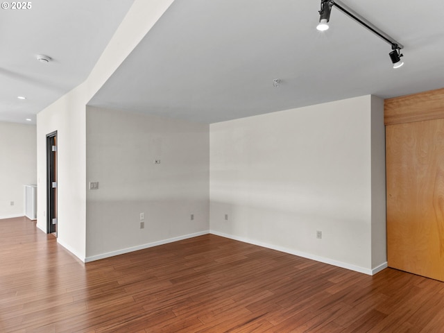 spare room featuring hardwood / wood-style floors and rail lighting