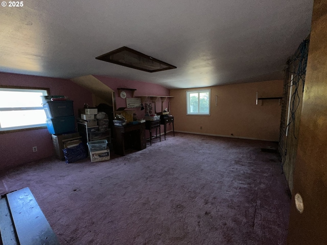 additional living space with dark colored carpet and vaulted ceiling