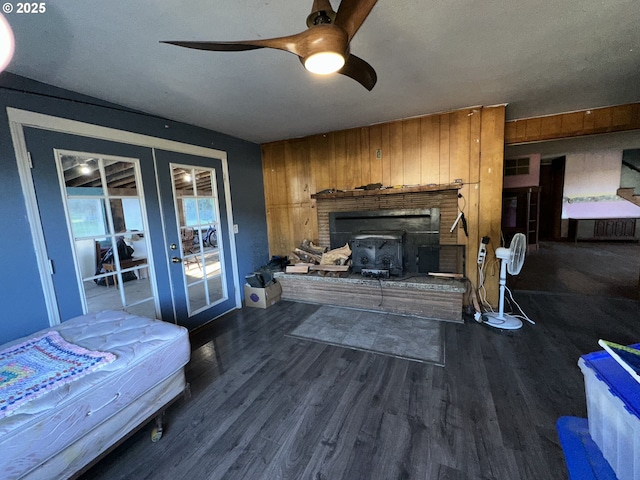 bedroom featuring ceiling fan, hardwood / wood-style floors, wooden walls, and french doors