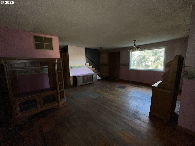 living room featuring dark wood-type flooring and a textured ceiling