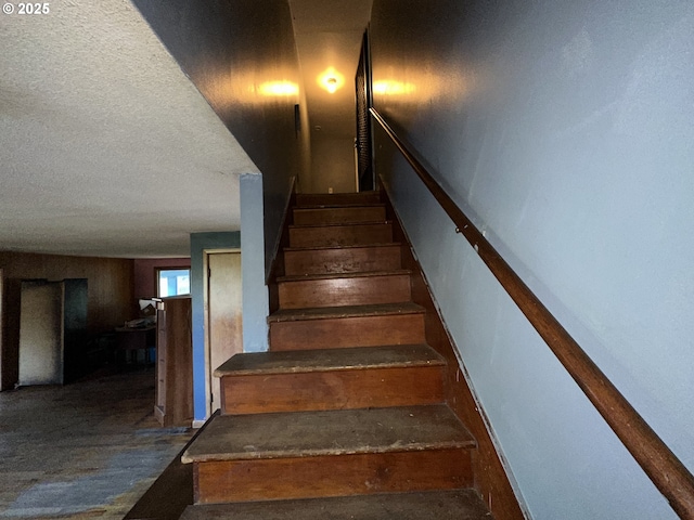 stairway featuring a textured ceiling